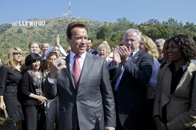 California Gov. Arnold Schwarzenegger, left , joins Los Angeles City Councilman Tom LaBonge, right, and officials from the Trust for Public Land to announce the success of the Save the Cahuenga Peak campaign, after raising $12.5 million to acquire Cahuenga Peak, a 138-acre parcel of land just west of the landmark Hollywood sign on Monday, April 26, 2010, in Los Angeles. (AP Photo/Damian Dovarganes)