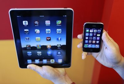 FILE - In this April 7, 2010 file photo, an Apple customer displays the new iPad, left, next to his iPhone in Palo Alto, Calif. Apple Inc., reports quarterly earnings Tuesday, April 20, 2010, after the market close. (AP Photo/Paul Sakuma, file)