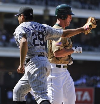 Colorado Rockies pitcher Jorge De La Rosa, left, tags out San Diego Padres Clayton Richard, right, as he tries to beat a ground ball to first base during the fifth inning of a baseball game Sunday, Sept. 5, 2010 in San Diego.  (AP Photo/Denis Poroy)