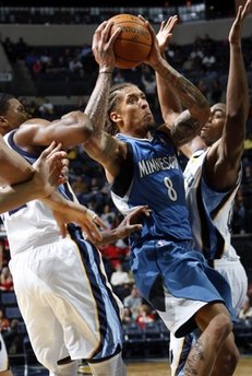 Minnesota Timberwolves forward Michael Beasley (8) drives to the basket defended by Memphis Grizzlies forward Rudy Gay, left, and Darrell Arthur, right, in the first half of an NBA basketball game Saturday, Oct. 30, 2010, in Memphis, Tenn. (AP Photo/Nikki Boertman)
