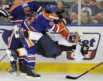 Edmonton Oilers Zack Stortini, left, levels Nashville Predators Patric Hornqvist during the first period of an NHL hockey game in Edmonton on Sunday, Jan. 23, 2011. Stortini was given a charging penalty on the play. (AP Photo/The Canadian Press, John Ulan)