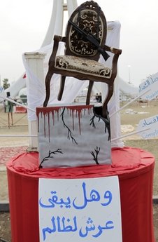 A chair representing  a throne  with a sign beneath it  that says in Arabic And does the throne of the oppressor stay , is seen at the Pearl Square in Manama, Bahrain, Monday, Feb. 21, 2011. (AP Photo/Hassan Ammar)