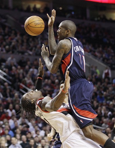 Portland Trail Blazers Gerald Wallace, left, takes a charge from Atlanta Hawks Jamal Crawford (11) in the third quarter during their NBA basketball game Sunday, Feb. 27, 2011, in Portland, Ore. The Hawks defeated the Trail Blazers 90-83. (AP Photo/Rick Bowmer)