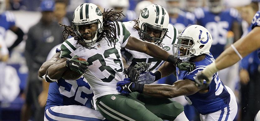 Indianapolis Colts inside linebacker Jerrell Freeman, bottom right, loses his helmet as he helps tackle New York Jets running back Chris Ivory (33) with Colts outside linebacker Trent Cole (58) in the first half of an NFL football game in Indianapolis, Monday, Sept. 21, 2015.  (AP Photo/Darron Cummings)