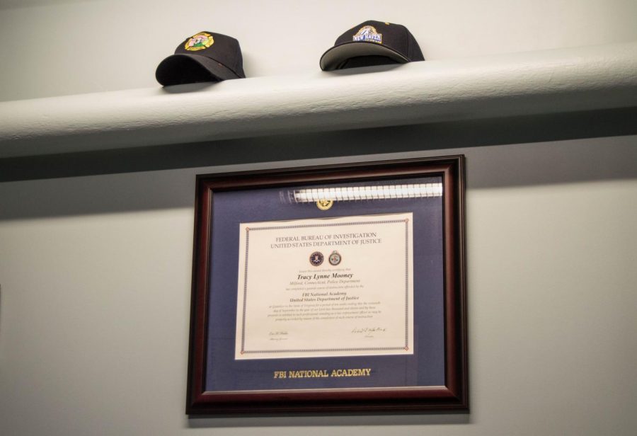 Police and university related hats and plaques of achievement adorn the walls in Chief Mooney’s office. 