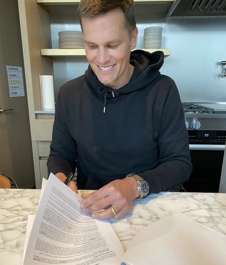 Tom Brady signing his contract to the Tampa Bay Buccaneers. 