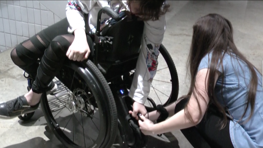 Jennifer Korn, Student Life Editor, helps Maisonet attach her wheelchair motor.