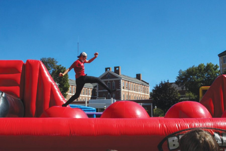 A student runs across an inflatable s at at Family Day, West Haven, Sept. 25, 2021
