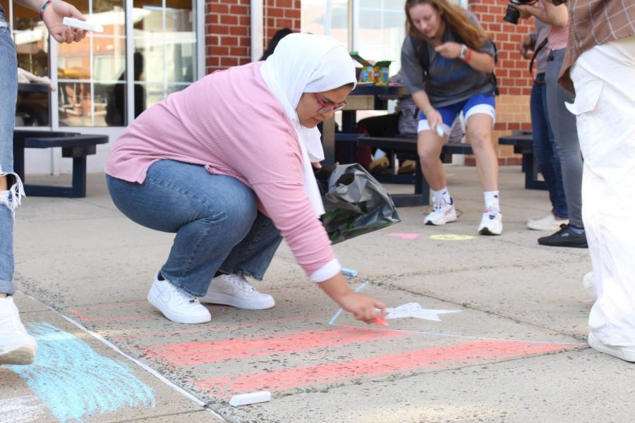 Adrielys Gomez draws the Puerto Rican flag on the sidewalk, Oct. 7, West Haven.