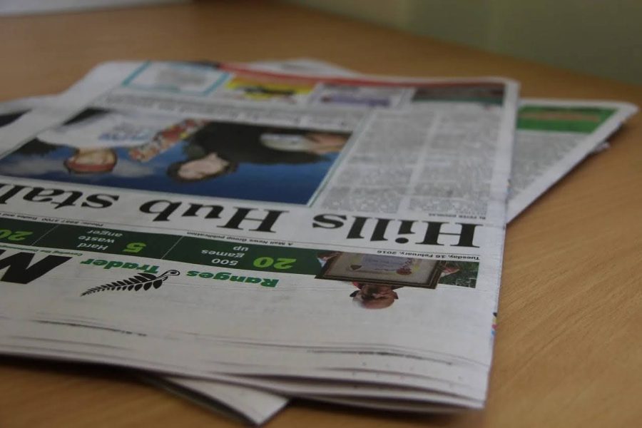 A stack of newspapers lies on a table.