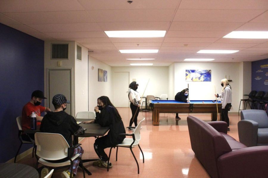 Students hang out while wearing masks inside of Bergami Hall., West Haven