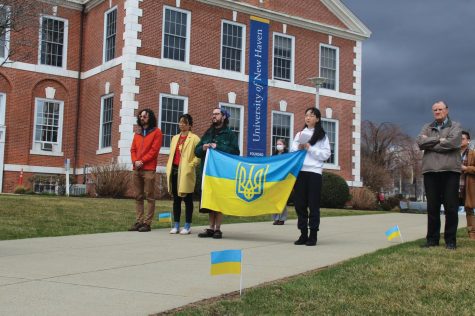 University community members hold up a Ukrainian flag with its coat of arms, April 1, 2022, West Haven.