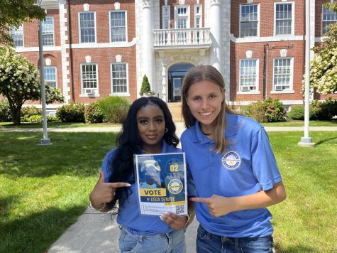 USGA President Saniyah Brinney (left) and Vice President of Operations Cora Cogil hold a poster with voting instructions, West Haven, Aug. 24.