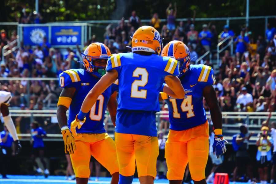 Carlyle (2), Holmes (0) and Kasi Hazzard (14) after a touchdown, West Haven, Sept. 10.