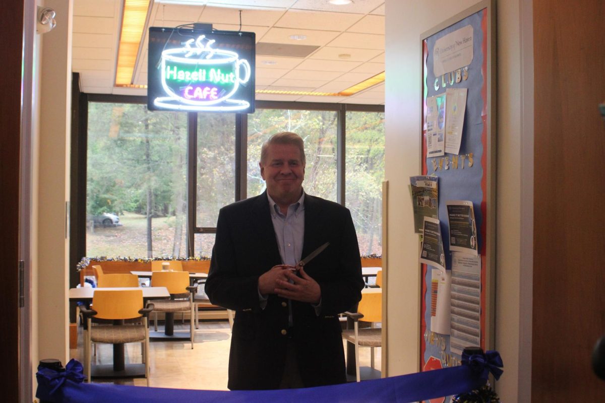 Jeffrey Hazell cutting the ribbon for the honorary ribbon cutting of Hazell Nut Cafe