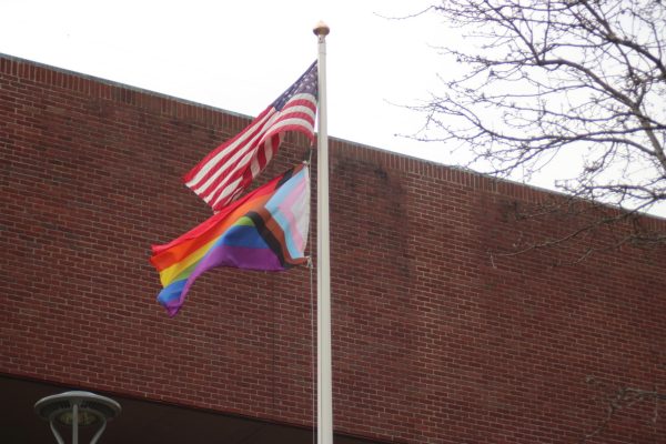 The American and Pride flags waving in front on Marvin K Peterson Library